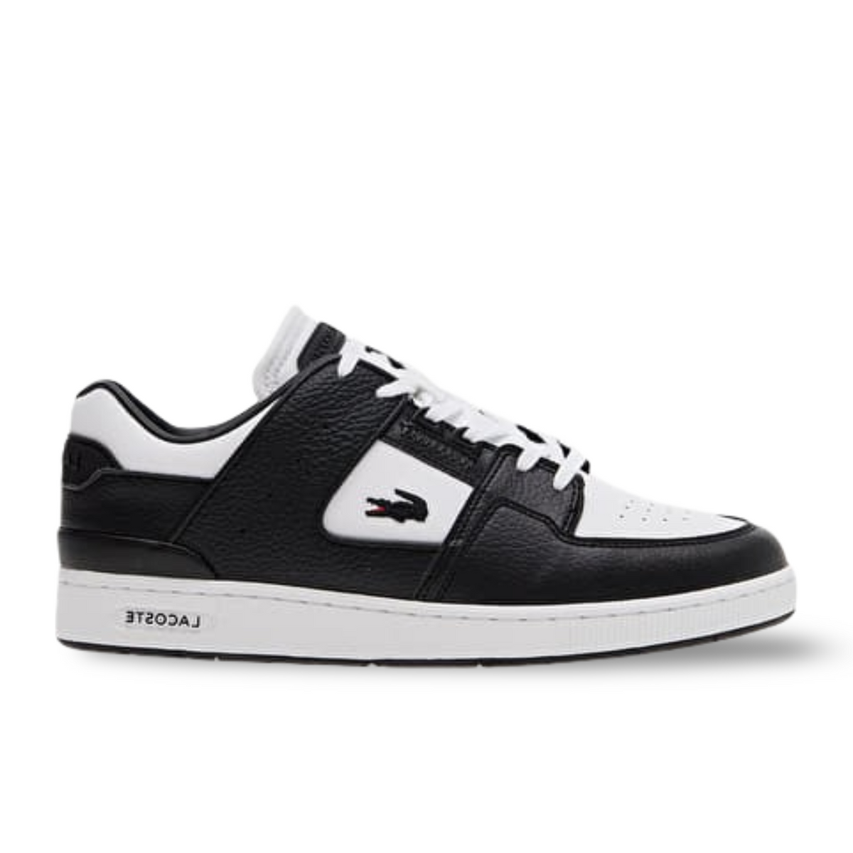 Black and white Lacoste low-top sneaker with a crocodile logo, shown from the side.