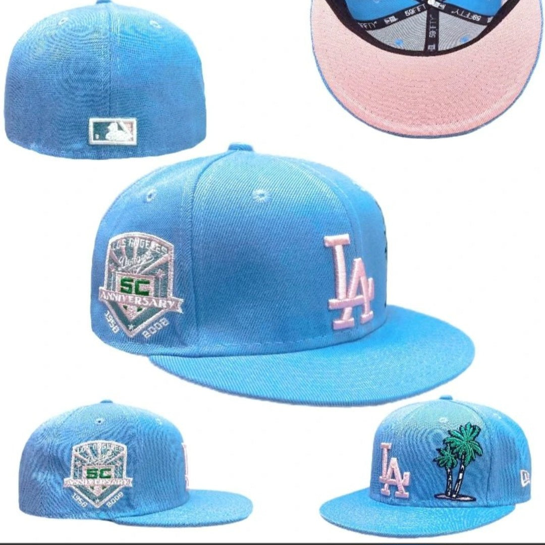New Era LA Fitted Cap – Light Blue: A light-blue fitted cap with contrasting LA embroidery, side detailing and a pink underside to the peak